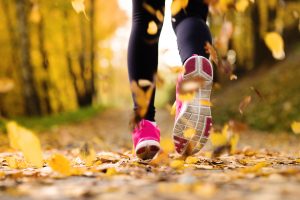 Close up of feet of a runner running in autumn leaves training exercise